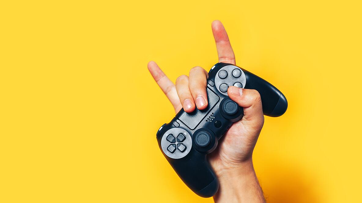 Hand eines Jugendlichen hält Controller hoch