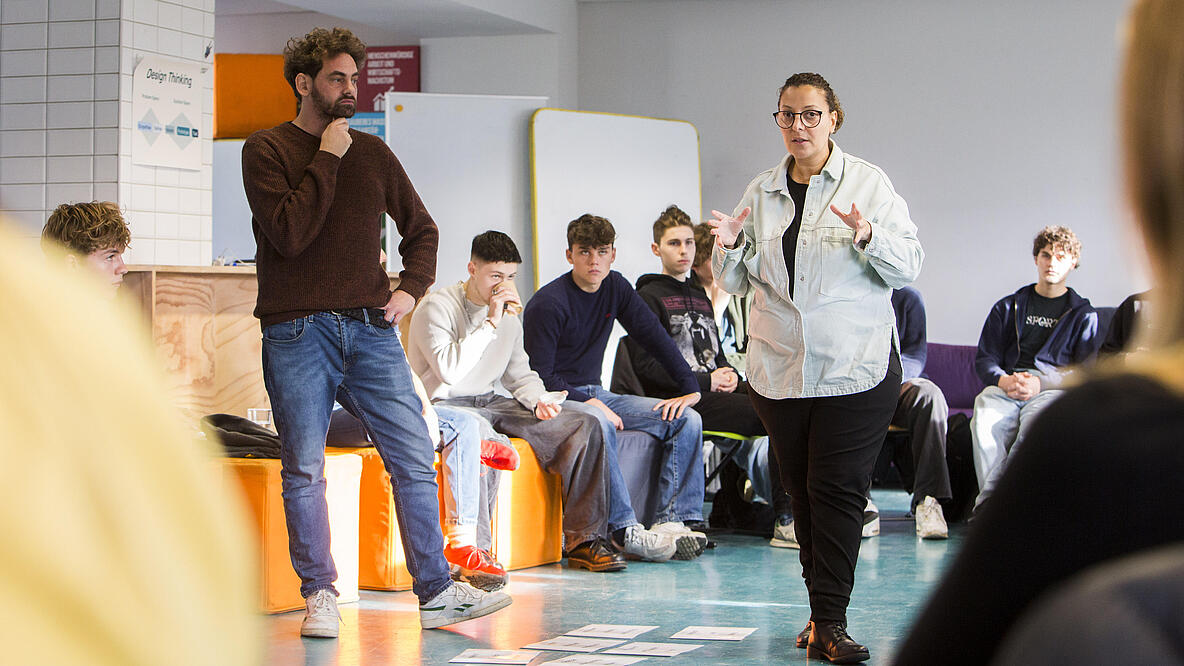 Jouanna Hassoun und Shai Hoffmann in der Mitte eines Stuhlkreises von Schüler*innen. 