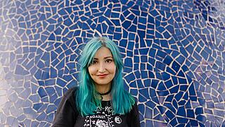 Porträt von Melina Borčak vor blauer Keramikwand