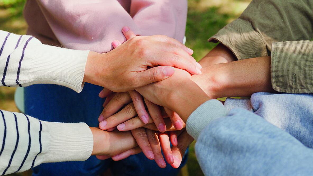 Viele Hände liegen übereinander