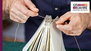 Hände, die ein Buch binden