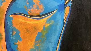 Ein Buddha-Gesicht mit orange-blauem Gesicht