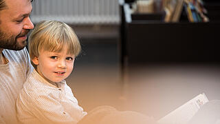 Mann und Kind lesen Buch