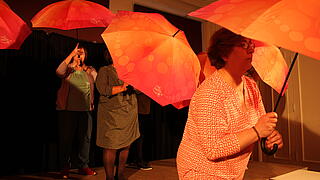 Menschen unter Regenschirmen