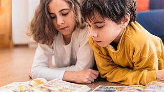 Foto von Kindern, die ein Comic lesen